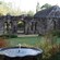 A medieval stone church and arcade in a garden with a fountain